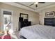 This bedroom includes a mirror, ceiling fan, and an open door to the balcony at 6625 Ferguson Dr, Whitestown, IN 46075