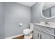 A well-lit powder room with a gray vanity, a large round mirror, and modern fixtures at 7115 N Lyndhurst Xing, McCordsville, IN 46055