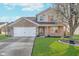 Charming two-story home with brick accents, landscaped yard, and blooming tree at 7115 N Lyndhurst Xing, McCordsville, IN 46055
