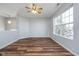 Loft area with wood floors, a ceiling fan, and a large window that fills the space with light at 7115 N Lyndhurst Xing, McCordsville, IN 46055