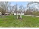 Green backyard with mature trees, a garden gate, and chain link fence providing a serene outdoor space at 7145 Lafayette Rd, Indianapolis, IN 46278