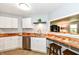 Bright kitchen with modern white cabinets, stylish wood countertops, and a convenient breakfast bar at 7145 Lafayette Rd, Indianapolis, IN 46278