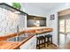 Updated kitchen with stainless sink, wood countertops, a breakfast bar, and view to the living area at 7145 Lafayette Rd, Indianapolis, IN 46278