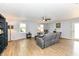 Bright living room with hardwood floors, neutral walls, ceiling fan, and comfortable gray sofa at 7145 Lafayette Rd, Indianapolis, IN 46278