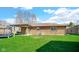 View of a spacious backyard with green grass, a covered patio, and blue trampoline at 715 Pioneer Dr, Indianapolis, IN 46217