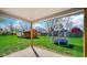 Covered patio view with green grass, backyard outbuilding, blue trampoline, and a wooden fence at 715 Pioneer Dr, Indianapolis, IN 46217