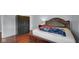 Cozy bedroom featuring a dark wooden bed frame, hardwood floors, and a built-in closet for storage at 715 Pioneer Dr, Indianapolis, IN 46217