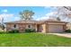 Charming single-story brick home featuring a two-car garage and well-maintained front lawn at 715 Pioneer Dr, Indianapolis, IN 46217