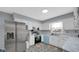 Bright kitchen featuring stainless steel appliances, white cabinets, and modern geometric flooring at 715 Pioneer Dr, Indianapolis, IN 46217