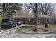 Charming single-story brick home featuring a pink garage door, lush landscaping and private driveway at 721 1St Ne Ave, Carmel, IN 46032