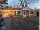 Brick home with mature trees, featuring a pink garage door and tidy front lawn at 721 1St Ne Ave, Carmel, IN 46032