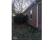 Side view of brick home showcasing lush foliage, brickwork, and gutter system at 721 1St Ne Ave, Carmel, IN 46032