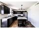 Modern kitchen with black cabinets, stainless steel appliances, marble countertops and a central island with seating at 729 Stonehenge Way, Brownsburg, IN 46112