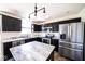 Modern kitchen with black cabinets, stainless steel appliances, marble countertops and a central island with seating at 729 Stonehenge Way, Brownsburg, IN 46112