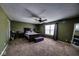 Spacious main bedroom with a ceiling fan, a large bed, and an upholstered bench with carpet flooring at 729 Stonehenge Way, Brownsburg, IN 46112
