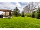 Expansive backyard with lush green grass and covered patio area, perfect for outdoor entertaining at 7326 Elm Ridge Dr, Indianapolis, IN 46236