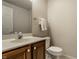 Powder room featuring a wood vanity with a white sink and a standard toilet at 7326 Elm Ridge Dr, Indianapolis, IN 46236
