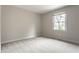 Minimalist bedroom showcasing natural light from a large window and neutral carpeting at 7326 Elm Ridge Dr, Indianapolis, IN 46236