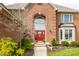 Charming red front door with holiday decorations and lush landscaping at the entrance at 7326 Elm Ridge Dr, Indianapolis, IN 46236