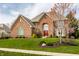 Attractive brick home with a manicured lawn, colorful landscaping, and mature trees at 7326 Elm Ridge Dr, Indianapolis, IN 46236