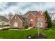 Attractive brick home with vibrant landscaping, a well-maintained lawn, and mature trees at 7326 Elm Ridge Dr, Indianapolis, IN 46236