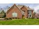 Inviting brick home with lush front lawn, mature landscaping, and classic architectural details at 7326 Elm Ridge Dr, Indianapolis, IN 46236