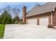 Spacious two-car garage and large concrete driveway of a red brick house at 7326 Elm Ridge Dr, Indianapolis, IN 46236