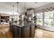 Bright kitchen featuring an island with granite countertops, stainless steel appliances, and large windows overlooking a garden at 7326 Elm Ridge Dr, Indianapolis, IN 46236