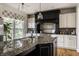 Modern kitchen boasts a large island with granite countertops, stainless steel appliances, and a black range hood at 7326 Elm Ridge Dr, Indianapolis, IN 46236
