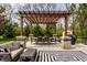 A furnished patio area with a pergola, comfortable seating, and a grill, ideal for outdoor living at 7326 Elm Ridge Dr, Indianapolis, IN 46236