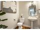 Stylish powder room featuring a pedestal sink, a decorative mirror, and modern fixtures with neutral walls at 7326 Elm Ridge Dr, Indianapolis, IN 46236