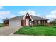 Single-story brick home featuring a well-manicured front lawn, attached garage, and classic design at 803 S School St, Brownsburg, IN 46112