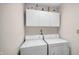 Functional laundry room with front-loading washer and dryer, and overhead storage at 803 S School St, Brownsburg, IN 46112