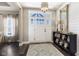 Inviting foyer with elegant light fixture, a large mirror, and a decorative console table at 978 S Fairway Village Ct, Greenfield, IN 46140