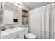Clean bathroom with a vanity, toilet, and shower with a striped curtain at 106 N Linwood Ave, Indianapolis, IN 46201