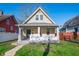 Charming two-story home featuring a gabled roof and inviting front porch framed by a well-manicured lawn under blue sky at 106 N Linwood Ave, Indianapolis, IN 46201