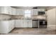 Well-lit kitchen with white cabinets, stainless steel appliances, and updated granite countertops at 106 N Linwood Ave, Indianapolis, IN 46201