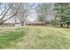 Spacious backyard featuring a well-maintained lawn, mature trees, storage shed, and brick home at 1132 Sheffield Dr, Avon, IN 46123