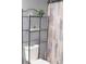 Bathroom featuring an over the toilet metal shelving unit, decorative items, and a decorative shower curtain at 1139 Topp Creek Dr, Indianapolis, IN 46214