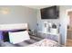 Well-lit bedroom features a comfortable bed, a TV mounted on the wall, and convenient storage solutions at 1139 Topp Creek Dr, Indianapolis, IN 46214