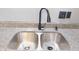 Close-up of a stainless steel kitchen sink with a modern black faucet and granite countertops at 1139 Topp Creek Dr, Indianapolis, IN 46214