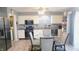 Charming kitchen area with modern lighting, stainless steel appliances, and a glass dining table at 1139 Topp Creek Dr, Indianapolis, IN 46214