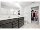 Bathroom with dual sinks, modern fixtures, and a walk-in closet, all with neutral colors at 11629 Brookwood Trace Ln, Indianapolis, IN 46229