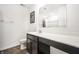 Modern bathroom with dark cabinets, white countertop, and a large mirror at 11629 Brookwood Trace Ln, Indianapolis, IN 46229