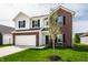 Beautiful two-story home featuring brick and siding exterior, complemented by a green lawn and young tree at 11629 Brookwood Trace Ln, Indianapolis, IN 46229