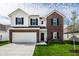 Inviting two-story home featuring a two-car garage, brick accents, and a well-manicured front lawn at 11629 Brookwood Trace Ln, Indianapolis, IN 46229