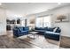 Open-concept living area featuring a sectional sofa, neutral rug, and views into the modern kitchen at 11629 Brookwood Trace Ln, Indianapolis, IN 46229