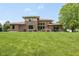The back of the brick home featuring a well-manicured lawn, a hot tub, and an outdoor grill and seating area at 13225 Gatman Ct, Carmel, IN 46032