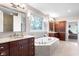 Bright bathroom with a large soaking tub, dual vanities, and a decorative window at 13225 Gatman Ct, Carmel, IN 46032