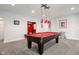 Spacious game room with a red felt pool table under modern pendant lighting and neutral walls at 13225 Gatman Ct, Carmel, IN 46032
